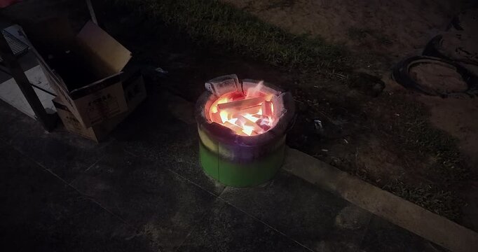 colorful charcoal stove burning at the edge of a beach at night.