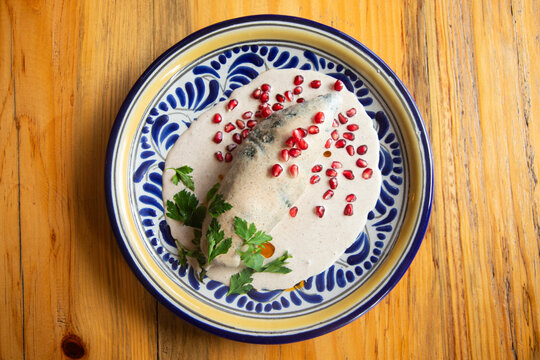 Chiles en Nogada: a traditional Mexican dish with poblano stuffed pepper with meat and creamy walnut sauce