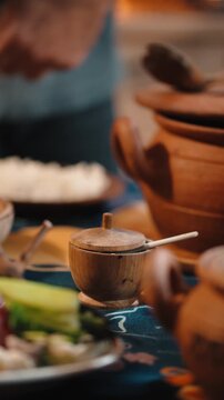 Traditional Georgian supra table set with clay dishes and a rich variety of food. Rustic textures, authentic tableware, and warm atmosphere showcase Georgian hospitality