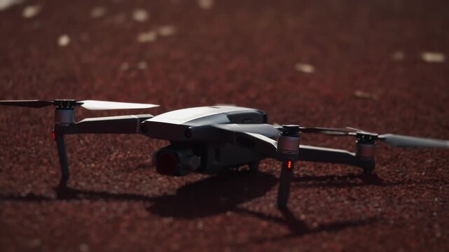 Drone lifting off from warm toned surface in shallow focus slow motion light