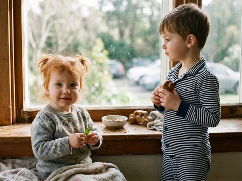 Little boy and girl enjoying a snack time inside home
