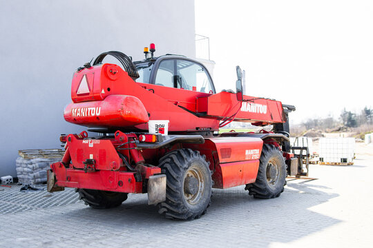 Swiebodzin, Polska - April 11, 2026: Manitou telehandler vehicle parked on a construction site with pallets and building materials visible in the background