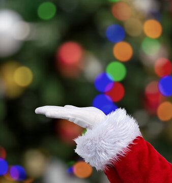 Shot of an Santa Claus hand with palm up at home with christmas tree