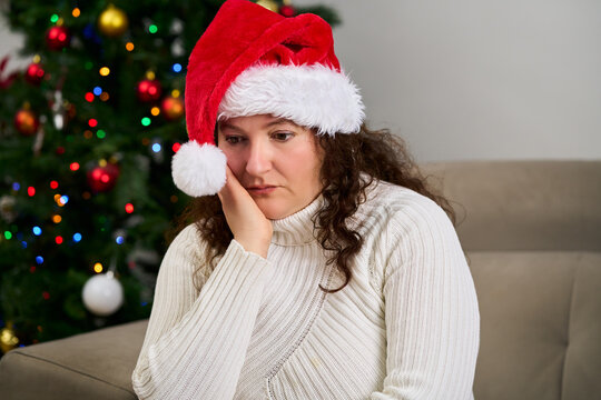 Sad, couch and woman in home on christmas with crying for depression, loneliness or hopeless. Mental health, holidays and person with tears and emotions for alone on xmas in living room at home.