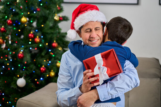 Happy family, father and hug with child for christmas celebration or December holiday in home.Father, embrace and son with smile in joy for festive weekend, bonding or love in house with copy space