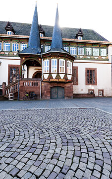 The Old Town Hall in Einbeck with its characteristic towers, half-timbered details and a wide cobblestone market square in bright daylight.