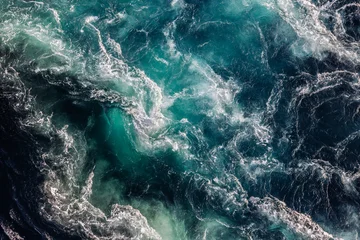 Blue waves of water of the river and the sea meet each other during high tide and low tide. © Andrei Armiagov