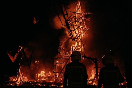 Firefighters standing in front of burning sculpture during Las Fallas festival in Valencia 2026