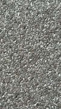 Close-up roof granules Uniflex waterproofing showing dense mineral granules embedded in dark asphalt membrane, high detail macro.
