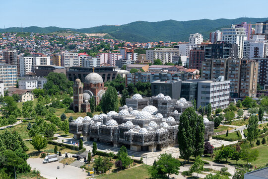 Aerial view of the National Library of Kosovo and the Cathedral church of Christ the Saviour with a mountain backdrop, Pristina, Kosovo