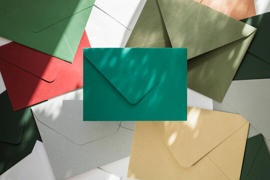 Full frame overhead view of assorted multi coloured envelopes on a table in dappled light