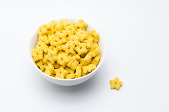 Bol de cereal en forma de estrellas sobre fondo blanco con espacio para text
