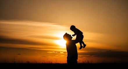 Fototapeta premium Father lifts child silhouetted against a vibrant sunset sky with warm golden light