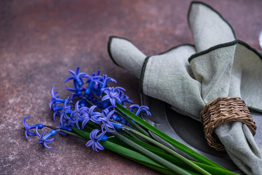 Close-up of a bunch of fresh blue hyacinths and a napkin on a ceramic plate