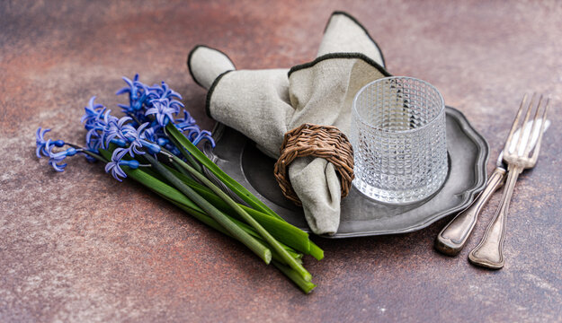 Close-up of a rustic spring place setting with fresh blue hyacinths on a table