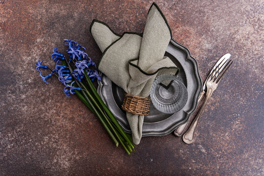Overhead view of a rustic spring place setting with fresh blue hyacinths on a table