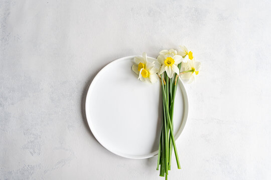 Overhead view of a bunch of fresh daffodils on a ceramic plate