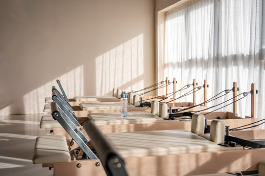 Bright Pilates reformers lined up in a sunlit studio