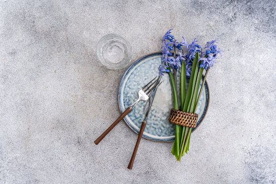 Overhead view of a rustic spring place setting with fresh blue hyacinth flowers