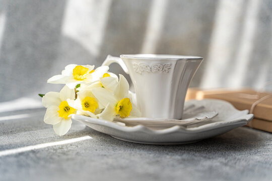 Close-up of freshly picked  daffodils on a ceramic tea set in the sunlight