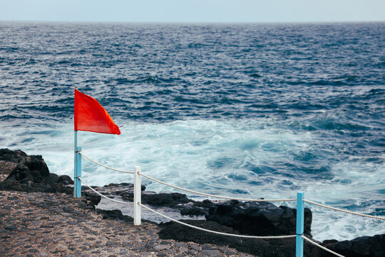 Red warning flag above rough Atlantic surf on La Palma