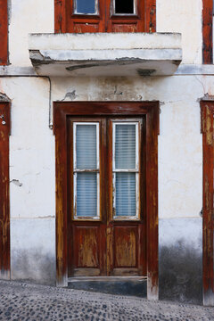 Weathered wooden door and stucco facade with peeling paint