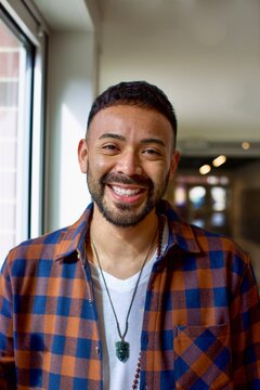 Portrait of a smiling man in casual clothing standing in a living room