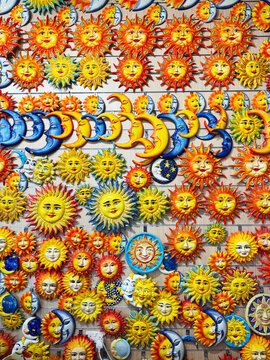 Full frame close-up of a traditional Maltese anthropomorphic sun and moon souvenirs hanging on a wall
