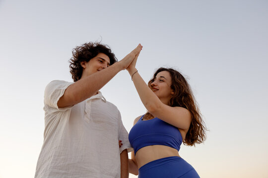 Couple giving a high five at sunset during outdoor time