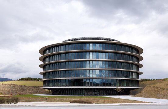 Modern glass office building exterior under cloudy sky