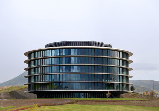 Modern circular glass office building exterior in landscape