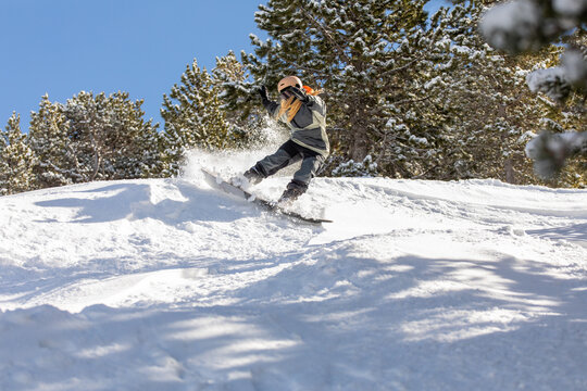 Woman snowboarding on snowy Pyrenees mountain slope