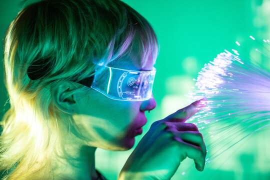 Young woman exploring futuristic metaverse with fiber optics