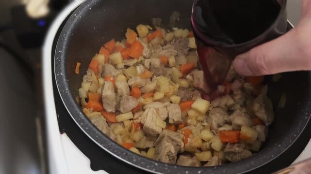 Adding of red wine to other ingredients during goulash cooking