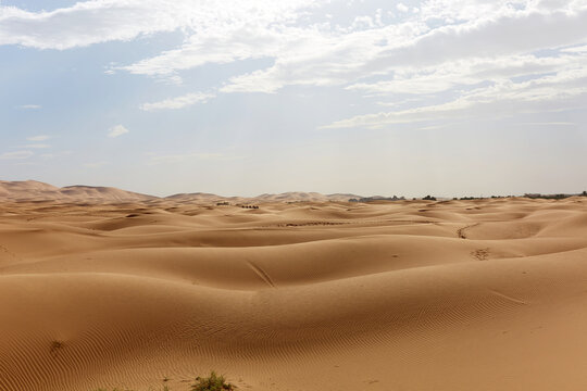 Golden sand dunes under cloudy sky in Morocco Sahara