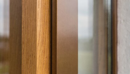 Naklejka premium Medium shot of bronzecolored woodaluminum clad windows showcasing warm wood interiors paired with sleek metal exteriors for enhanced thermal insulation and durability.