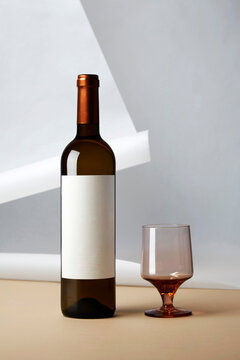 Minimalist wine bottle and glass with blank label mockup