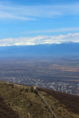 Obraz premium Aerial view of the old city's fortress wall. The village, the Alazani Valley, the Caucasus Range, and snow-capped mountains in the background. Sighnaghi, Kakheti, Georgia