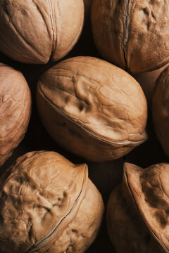 Close-up of whole walnuts on dark background texture