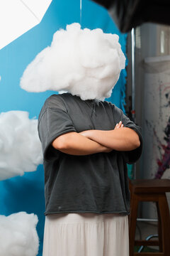 Person with arms crossed and cloud obscuring face