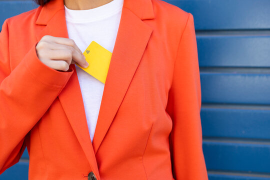 Businesswoman with credit card in orange suit