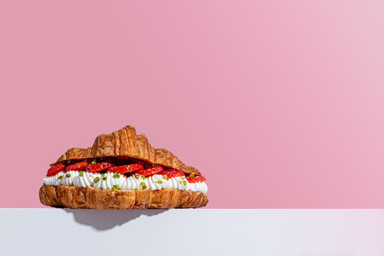 Croissant with Strawberry and Cream on Pink Background