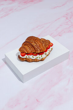 Strawberry cream croissant on marble background