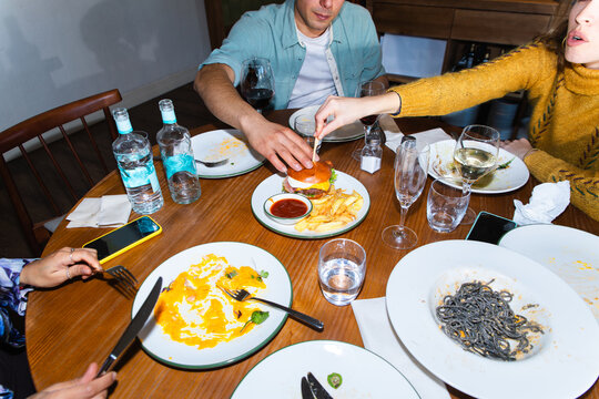 Friends sharing dinner and drinks at a cozy restaurant table