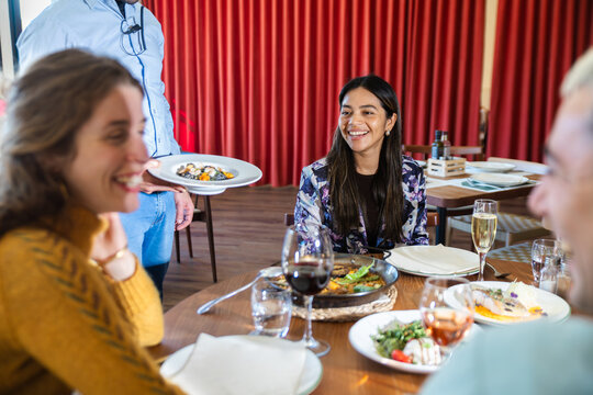 Friends enjoying Mediterranean dinner at a restaurant table