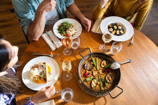 Friends sharing Mediterranean food and wine at restaurant