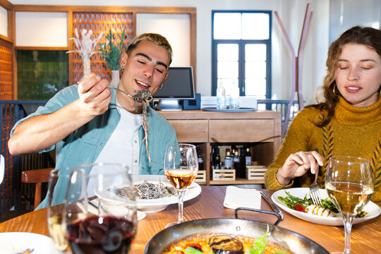 Friends enjoying Mediterranean paella dining in restaurant