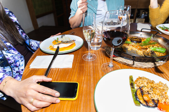 Friends sharing Mediterranean paella dinner at restaurant table