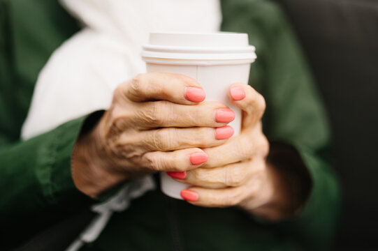 Close-up of hands holding takeaway coffee cup outdoors