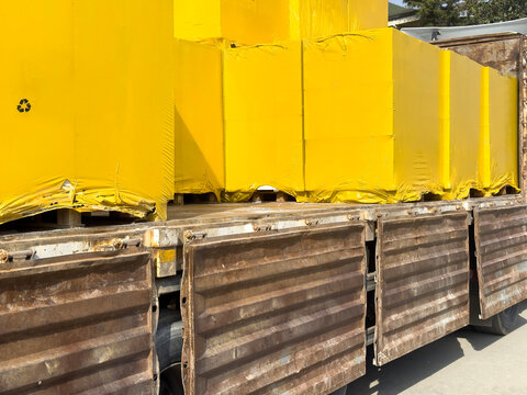 Yellow wrapped cargo pallets on flatbed truck for transport